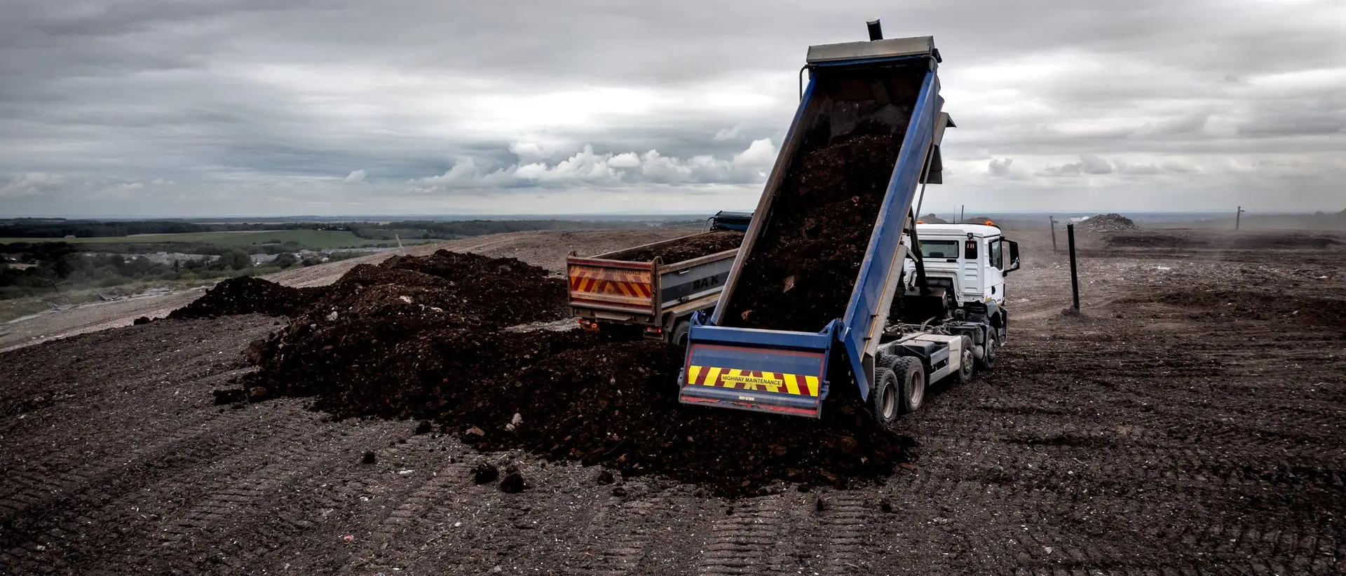 Tipper truck discharging excavated soil at a receiving facility