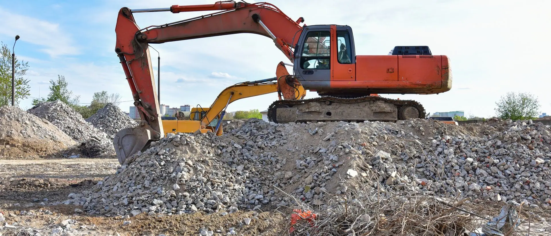 Excavator working concrete demolition waste for recovery